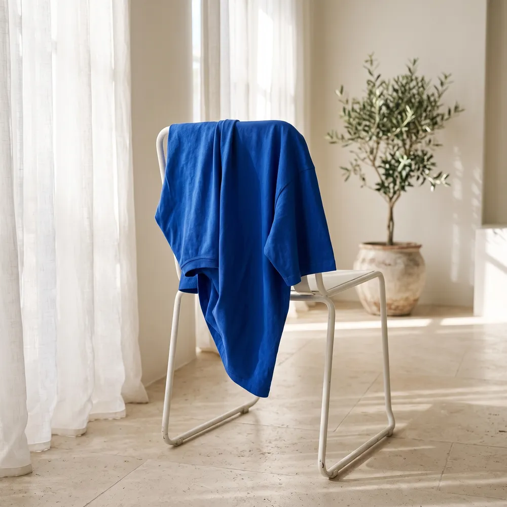The tee over a white chair in a sunlit room